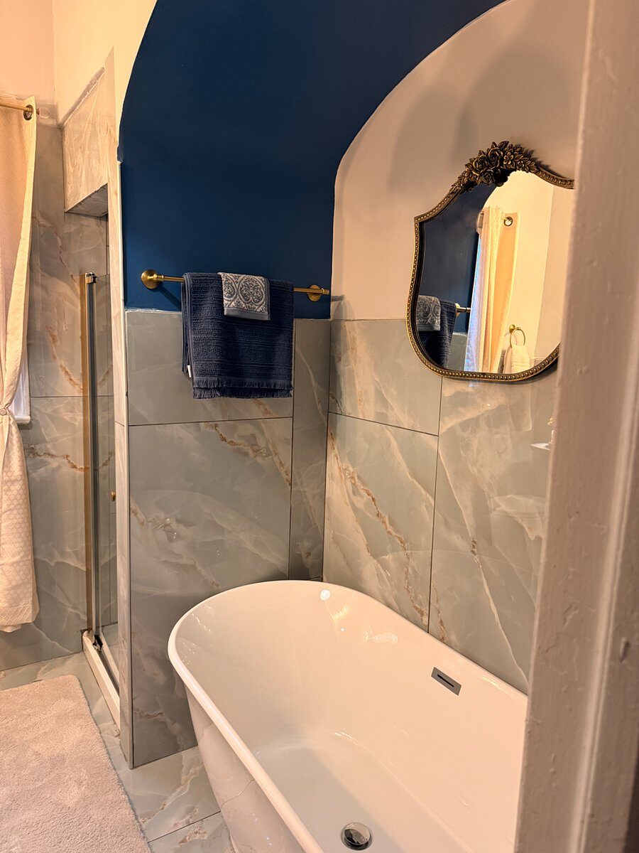 Blue Magnolia bathroom with walk-in shower and round mirror