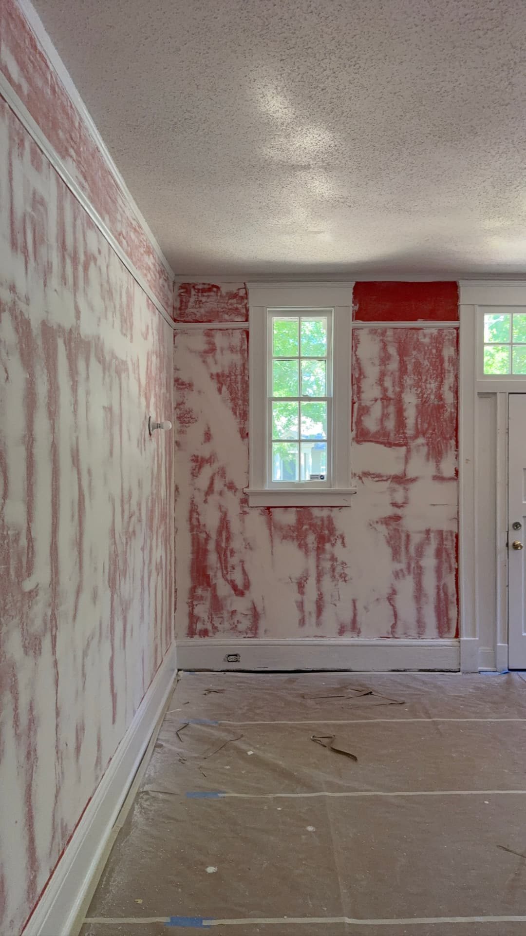 Lawrence project — front room with red paint stripped back from the plaster walls