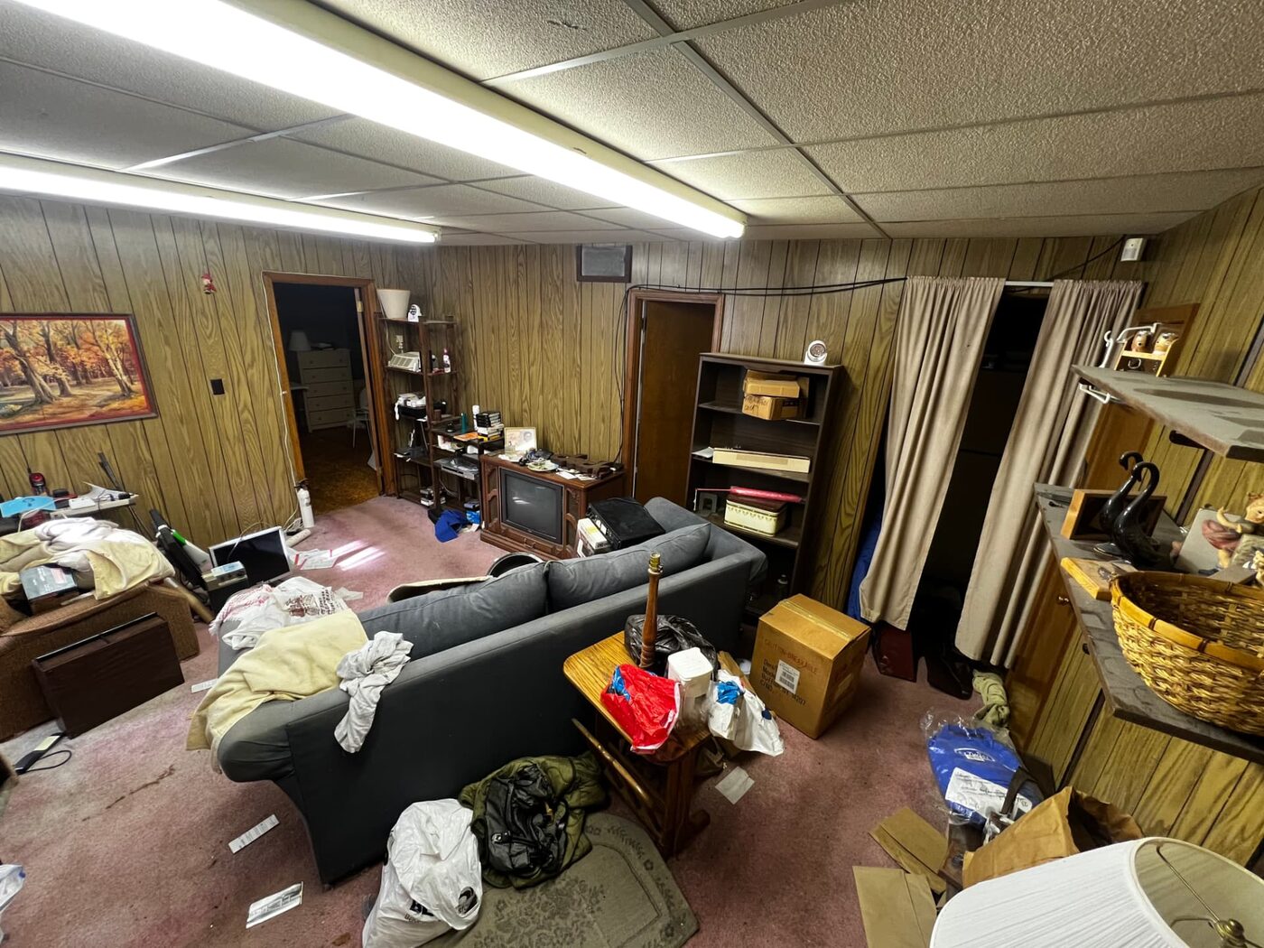 Rosedale project — lower level den before renovation, wood paneling and drop ceiling