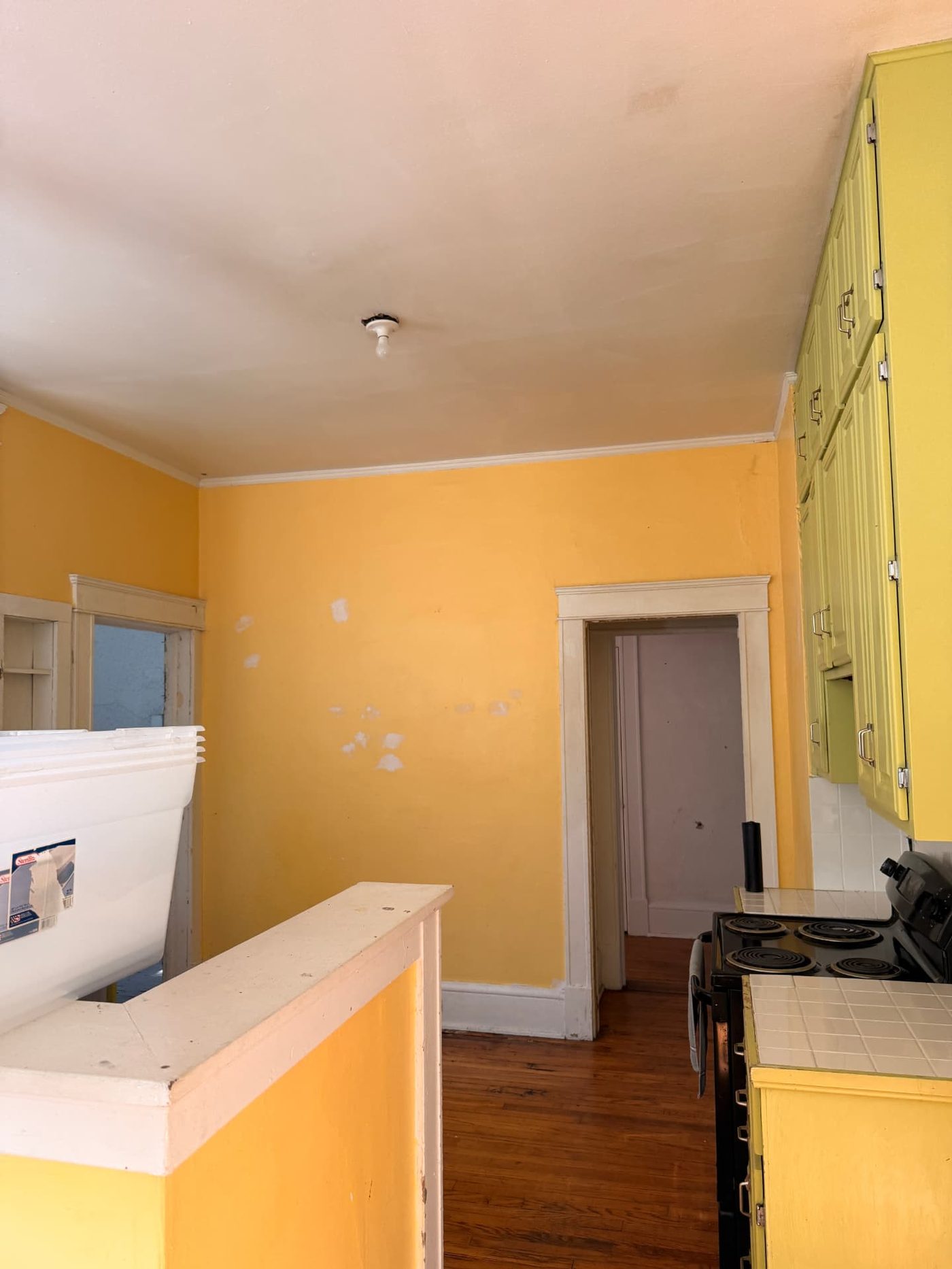 Lawrence project — kitchen before renovation, yellow walls and painted wall cabinets