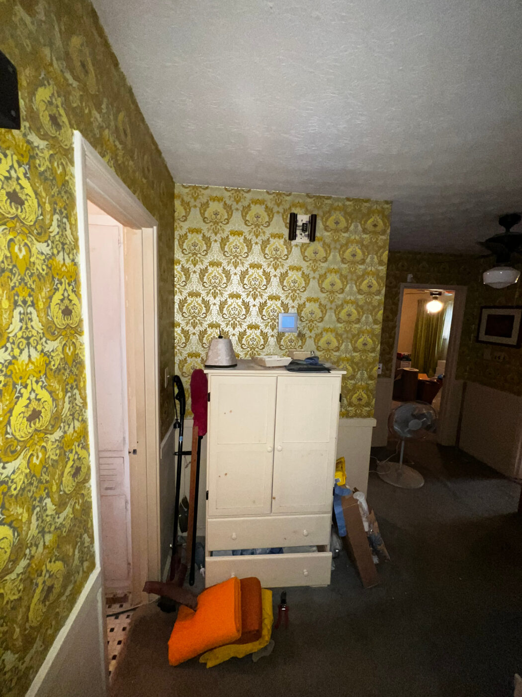 Rosedale project — hallway before renovation, patterned wallpaper and carpet
