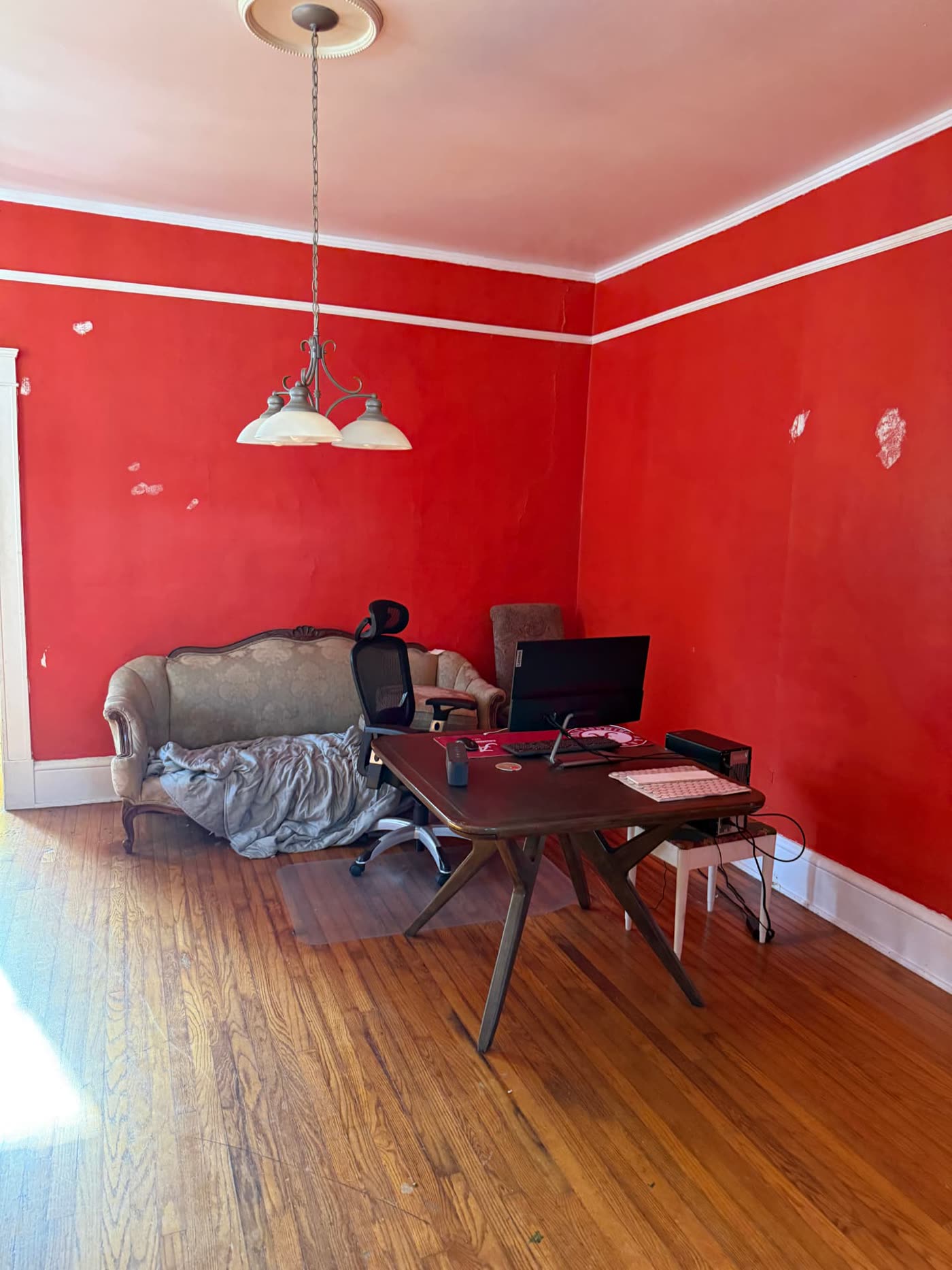 Lawrence project — front room before renovation, red plaster walls and original heart pine floors